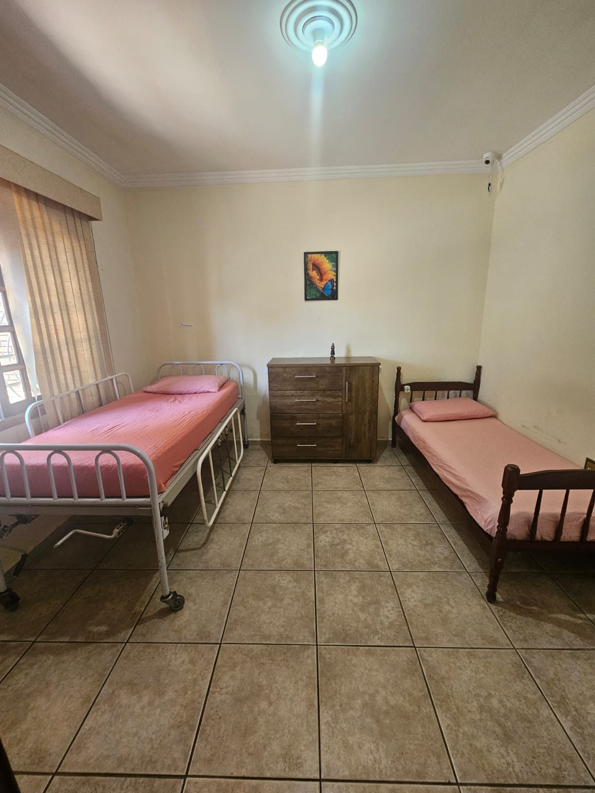 Quarto com cama hospitalar e cômoda