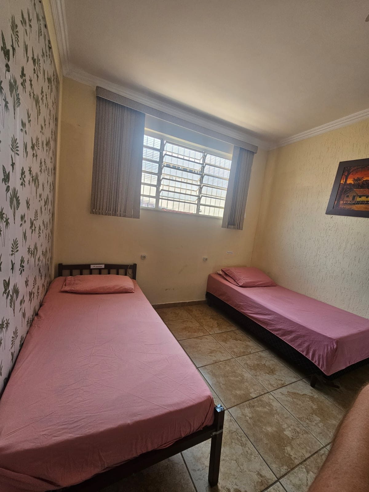 Quarto claro com duas camas e janela ampla