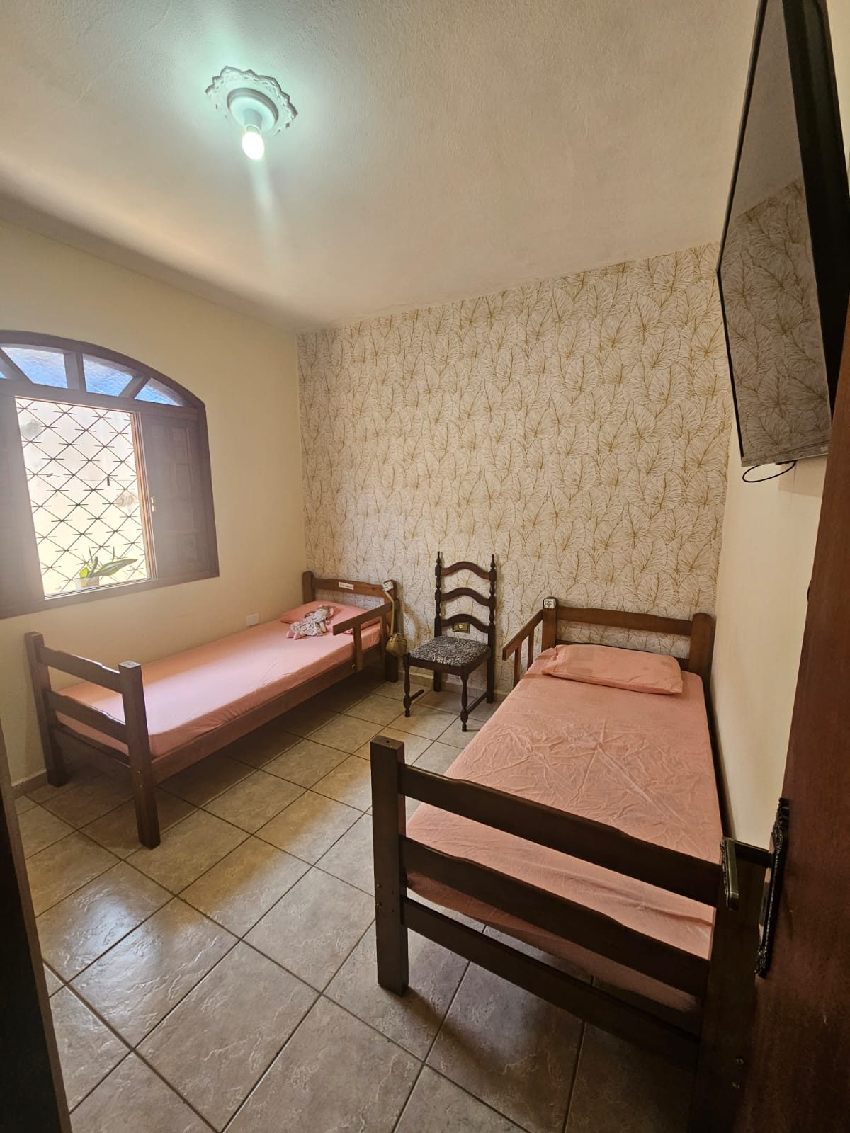 Quarto aconchegante com duas camas e TV