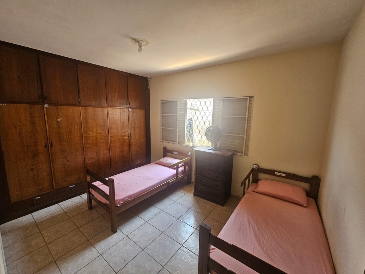 Quarto com guarda-roupa e duas camas