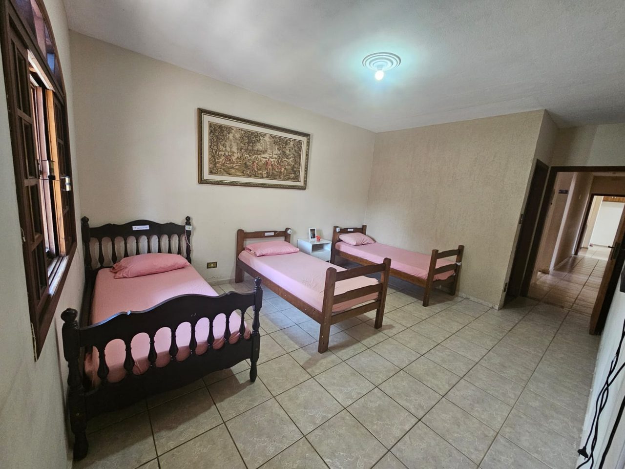 Quarto com três camas e vista para o corredor