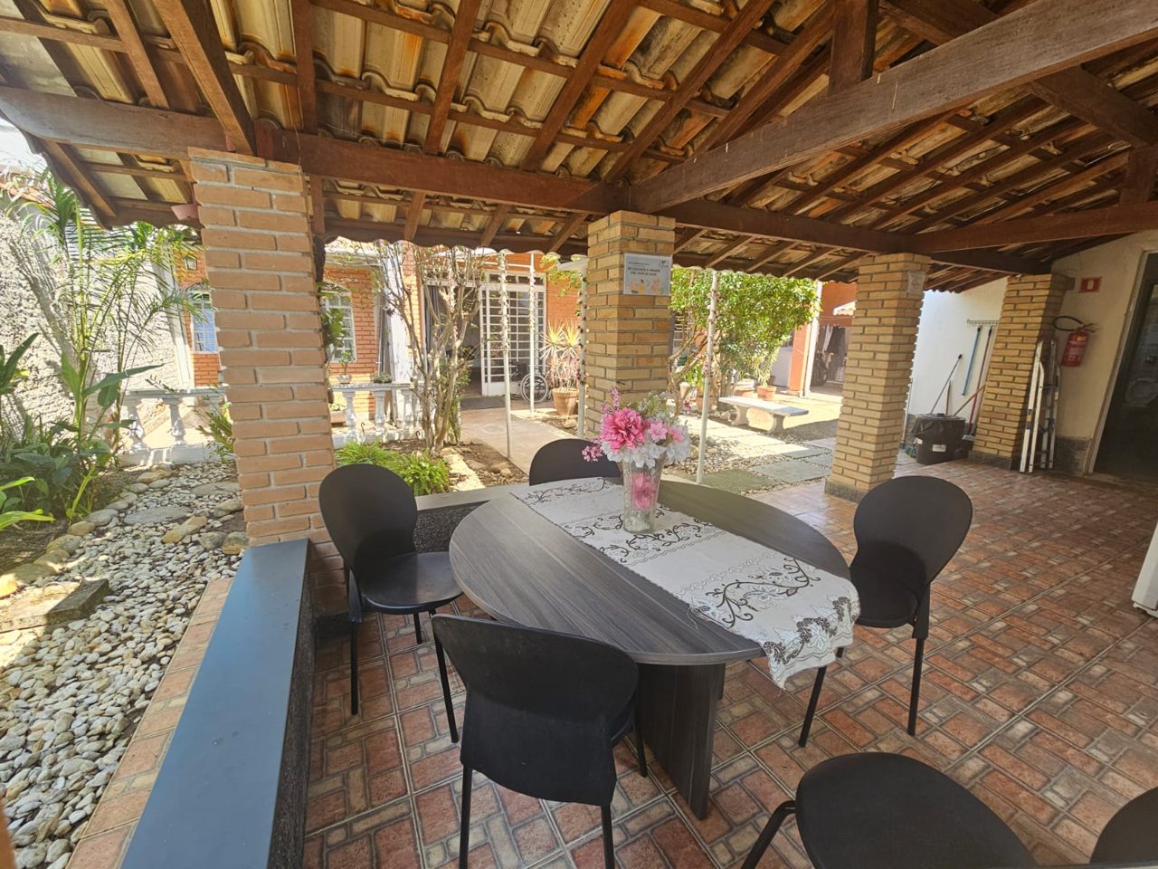 Área gourmet com mesa sob o pergolado